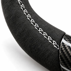 Gros plan sur une couture blanche sur le côté en alcantara d'un volant carbone