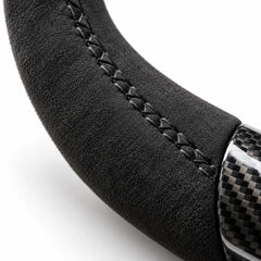 Gros plan sur une couture noire sur le côté en alcantara d'un volant carbone