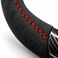 Gros plan sur une couture rouge sur le côté en alcantara d'un volant carbone