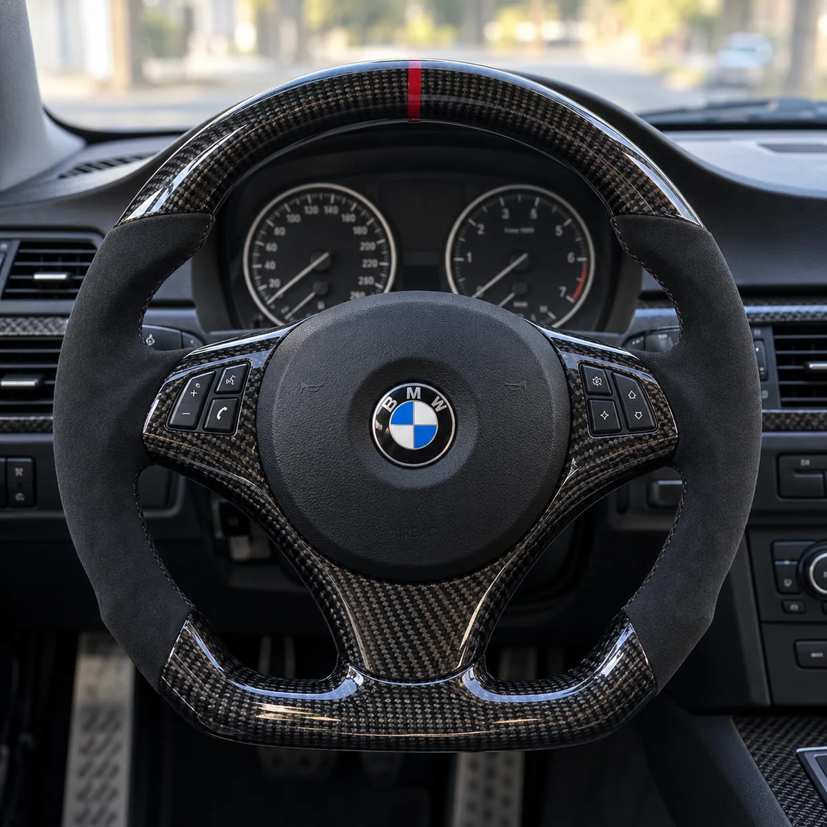 Volant carbone et alcantara monté dans une BMW E46, vu depuis le siège conducteur