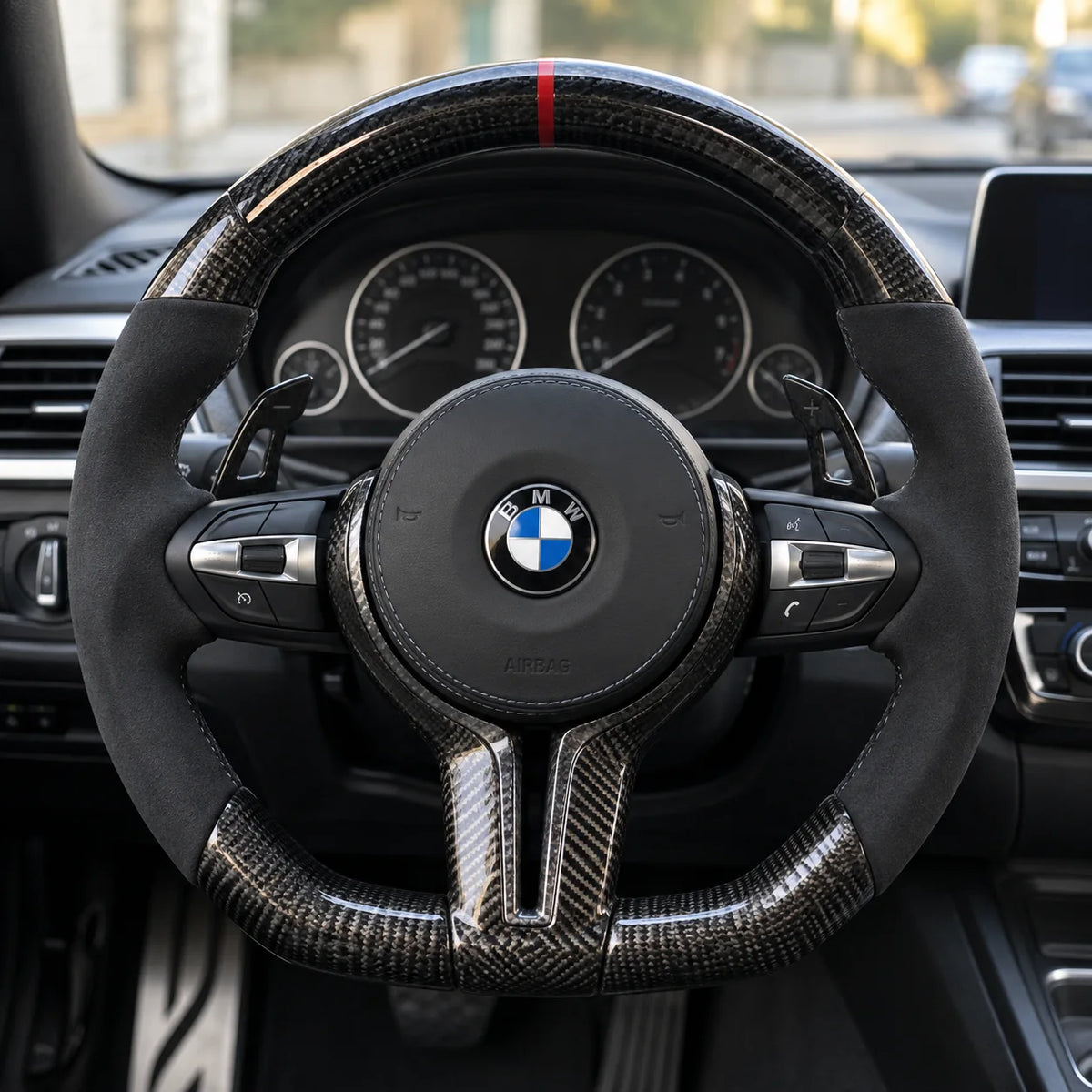 Volant carbone et alcantara monté dans une BMW F30, vu depuis le siège conducteur