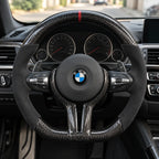 Volant carbone et alcantara monté dans une BMW M3 F80, vu depuis le siège conducteur