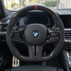 Volant carbone et alcantara monté dans une BMW M3 G80, vu depuis le siège conducteur