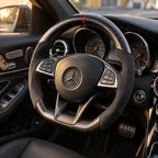 Mercedes A45 AMG : volant monté vu depuis le siège passager, bas plat et carbone brillant
